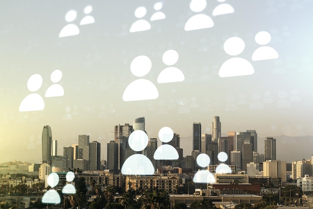 Double exposure of social network icons hologram on Los Angeles office buildings background Networking concept