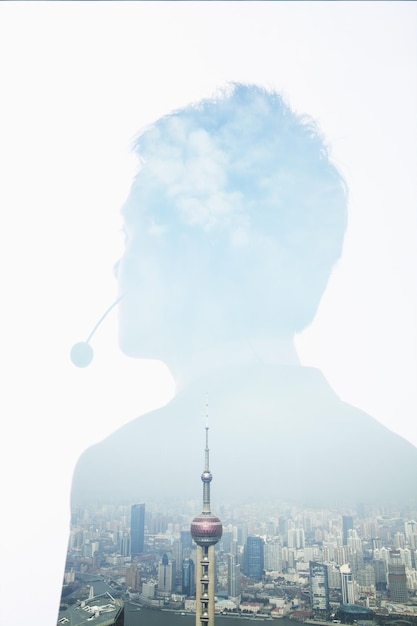 Double exposure of young businessman with headset and the skyline of Shanghai China