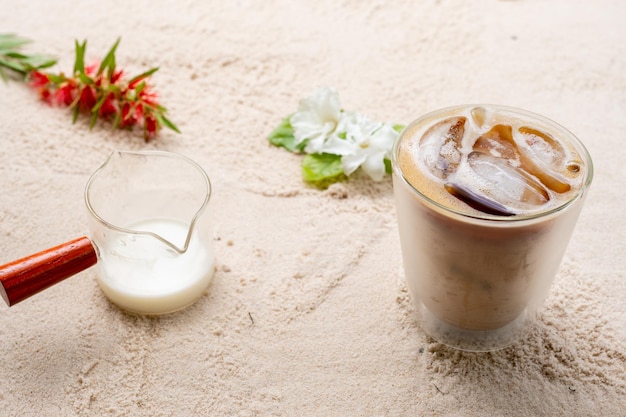 Double glass latte on sand beach background.