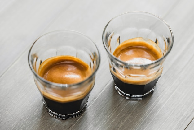 Photo double shot espresso coffee in the glasses on vintage wood table