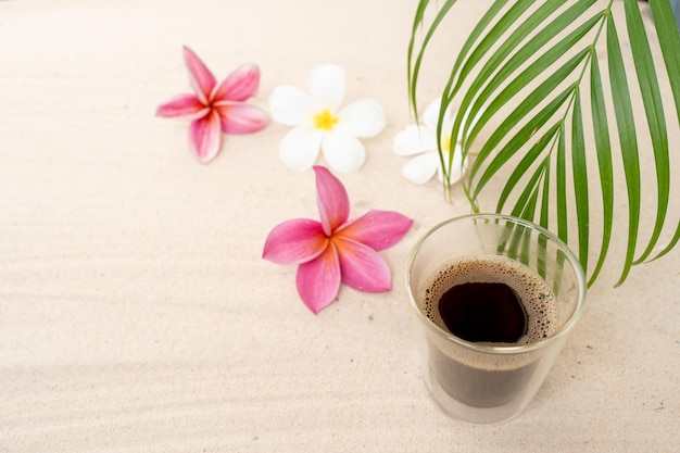 Double Wall Glass Espresso On Sand Beach Next To Frangipani Flowers