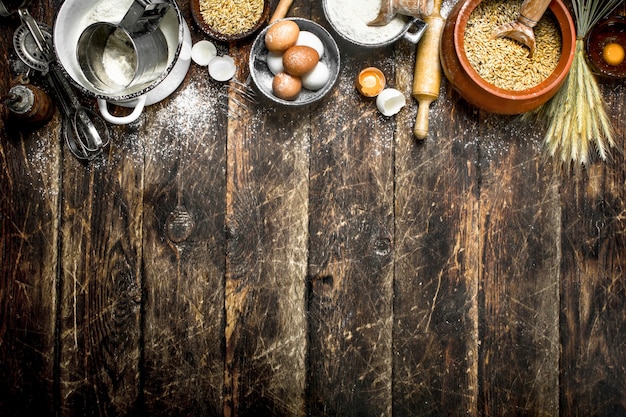 Dough background. Flour with wheat grains and fresh eggs.