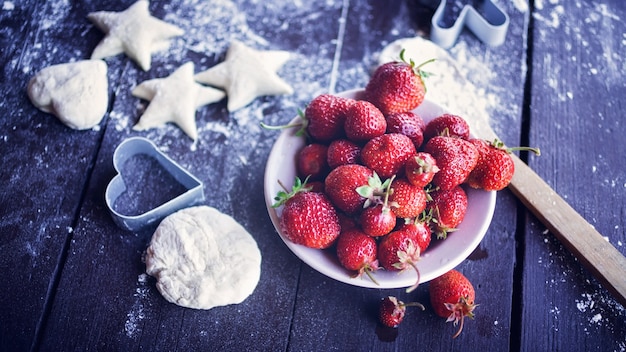 Dough for cookies, ripe strawberry and berries of a honeysuckle. Food composition 