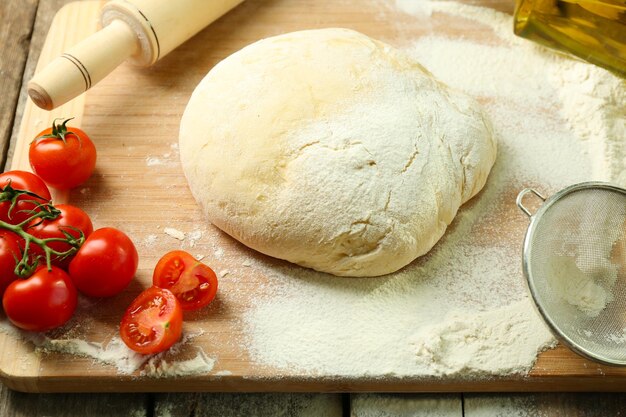 Dough on cutting board with cherry on table close up