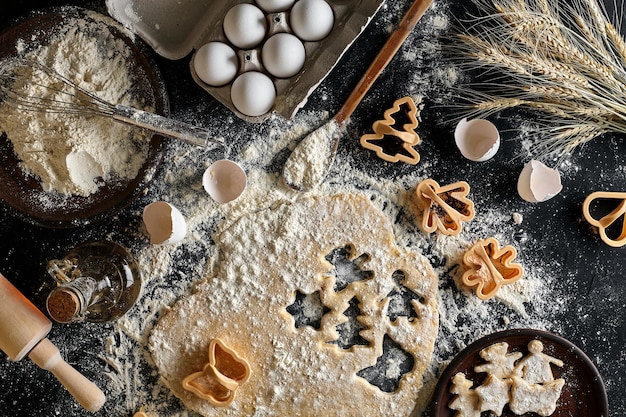 Dough for ginger biscuits rolled up on a table and cut using molds