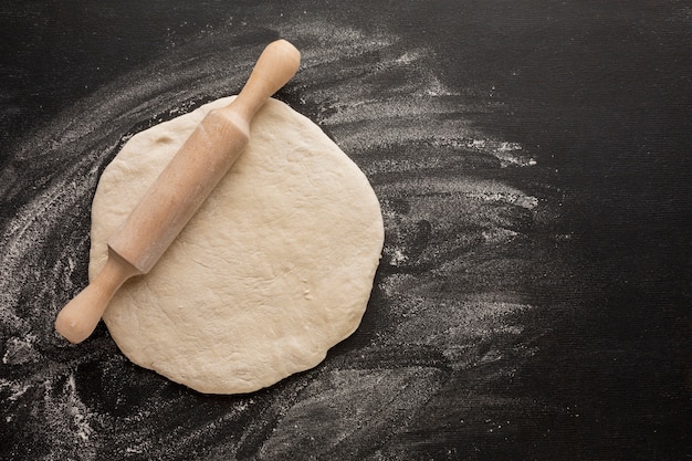 Dough with rolling pin on flour