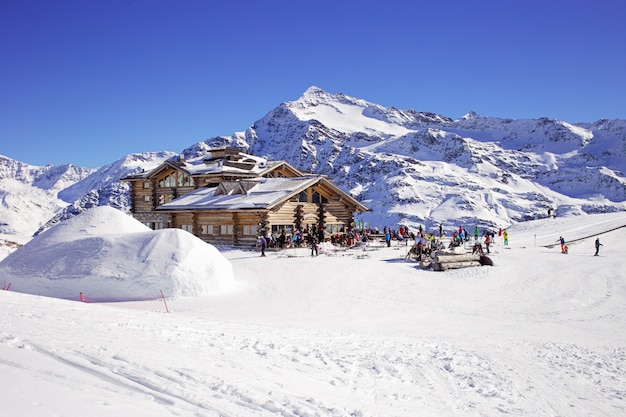 Downhill slope and apres ski mountain hut with restaurant terrace in the Italian Alps, Europe, Italy. Ski area Santa Caterina Valfurva