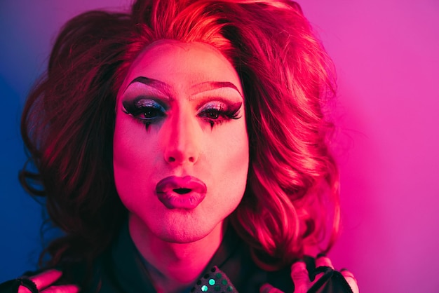 Drag queen looking at camera with neon color lights inside studio  Lgbtq concept