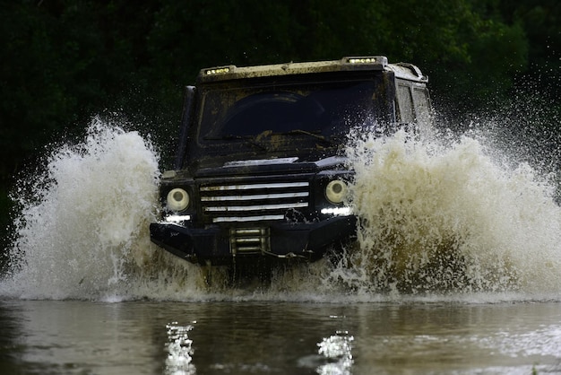 Drag racing car burns rubber. Extreme. Mudding is off-roading through an area of wet mud or clay. Off-road car. Off-road vehicle goes on mountain way. Jeep outdoors adventures.