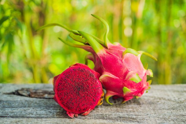 Dragon fruit on old wooden table on bamboo background