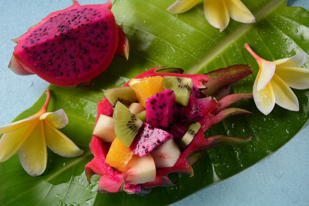 Photo dragon fruit (pitaya, pitahaya).sliced pieces pitahaya fruit and fruit salad,and frangipani flowers.