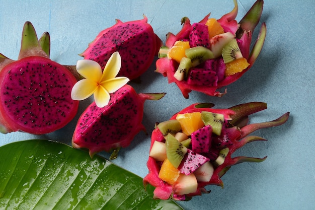 Photo dragon fruit (pitaya, pitahaya).sliced pieces pitahaya fruit and fruit salad,and frangipani flowers.