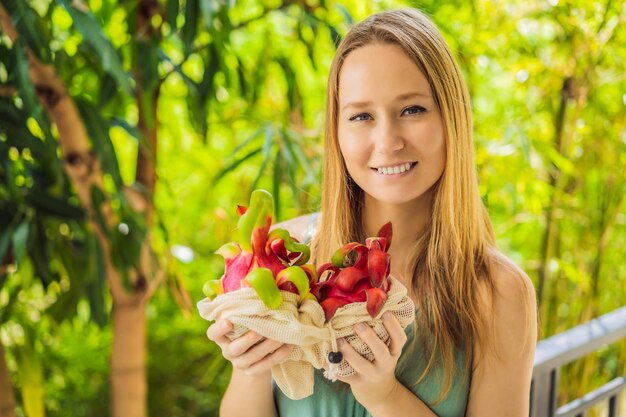 Dragon fruit in a reusable bag in female hands zero waste concept plastic free concept healthy clean