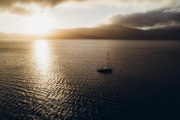 Dramatic photograph of the ocean landscape with a boat and mountains on the horizon high quality