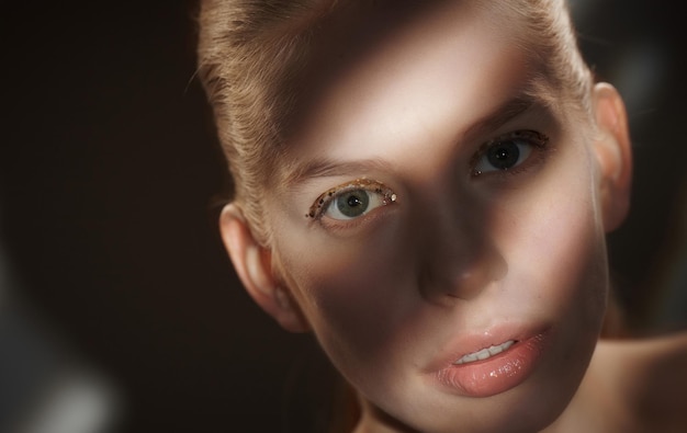 Dramatic portrait of woman with lights and shadows on her face.