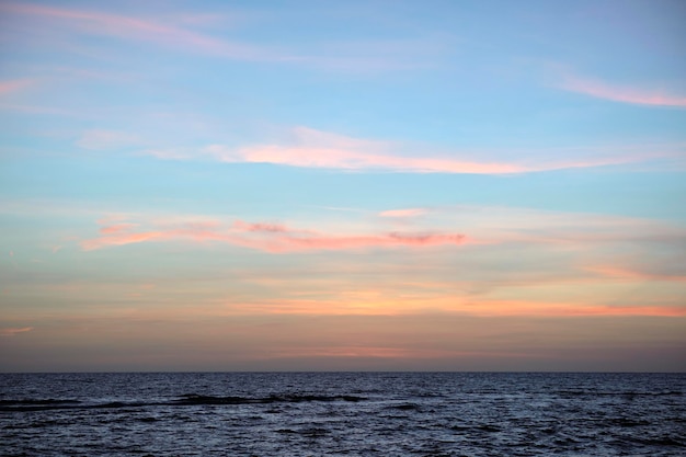 Dramatic red ocean waves at sunset with soft evening sea dark water