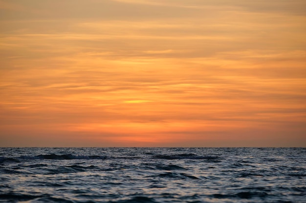 Dramatic red ocean waves at sunset with soft evening sea dark water