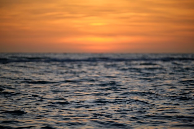 Dramatic red ocean waves at sunset with soft evening sea dark water