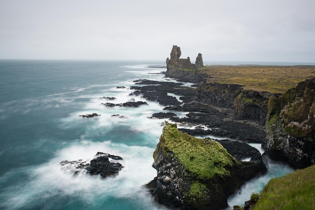 Dramatic scandinavian sea landscape with big cliffs and moody sky Iceland outdoor travel background Long exposure