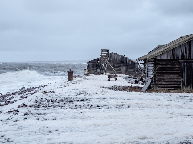 Dramatic seascape with a raging White sea and a fishing hut on the shore. Kandalaksha bay. Umba. Russia.