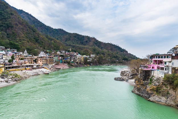 Dramatic sky at Rishikesh, holy town and travel destination in India. Colorful sky and clouds reflecting over the Ganges River. 