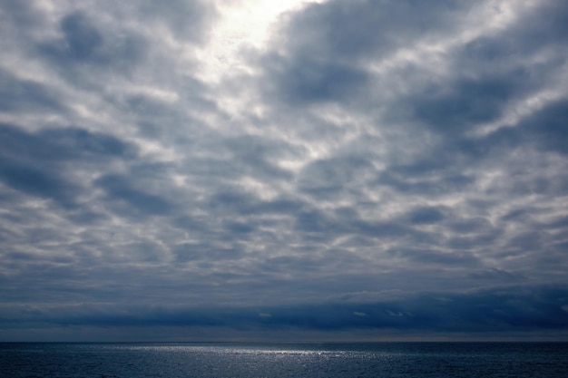 Dramatic stormy dark cloudy sky over sea natural photo background