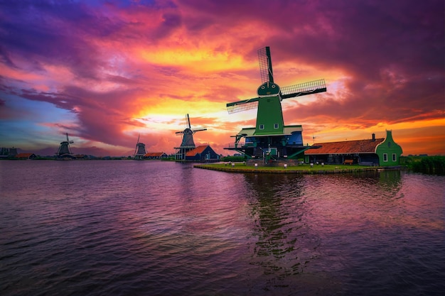 Dramatic sunset above farm houses and windmills of zaanse schans netherlands