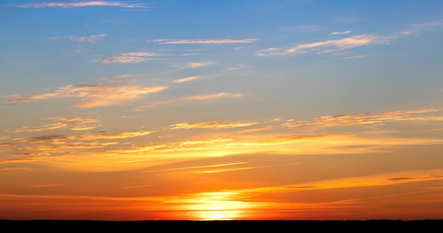 Dramatic sunset, the sun's rays shine through the clouds.