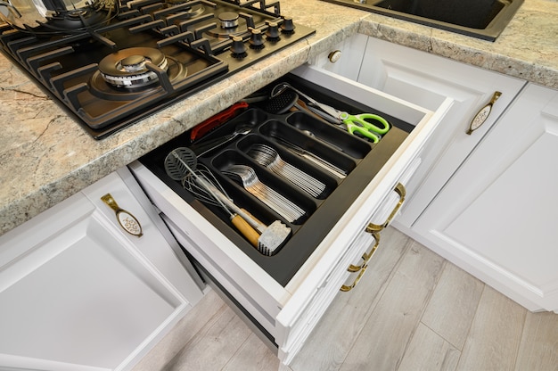 Drawers pulled out at modern classic white kitchen furniture