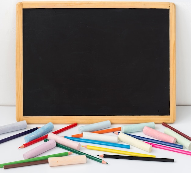 Drawing Board with pencils and crayons on a white background with a copy of the space.