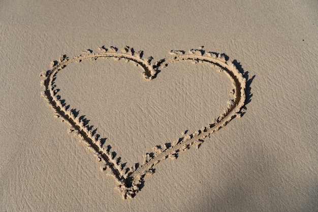 Drawing of hart in the sand the symbol for love concept of relationship and togetherness