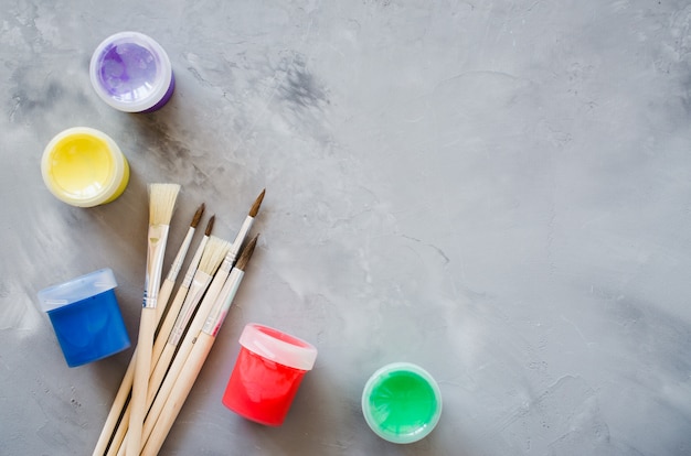 Drawing tools, set of clean paint brushes and multicolor paints.