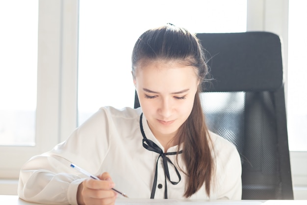 Drawing up a contract for the sale of cars, real estate. Woman puts a signature