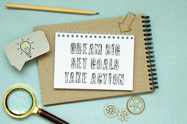 Photo dream big set goals take action text quote on notepad concept background