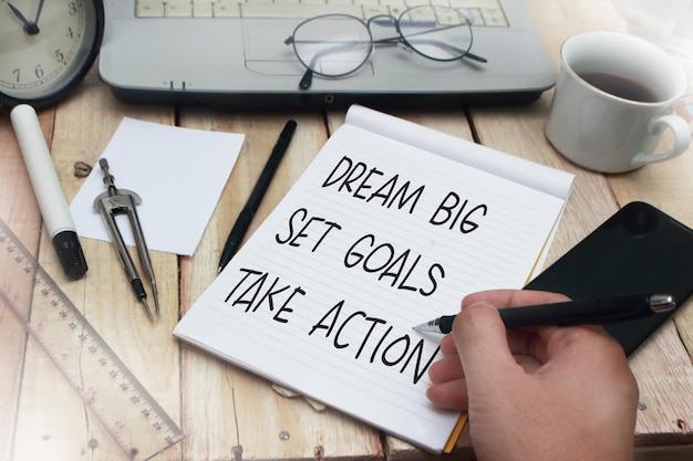 Photo dream big set goals take action words letter written on notepad work