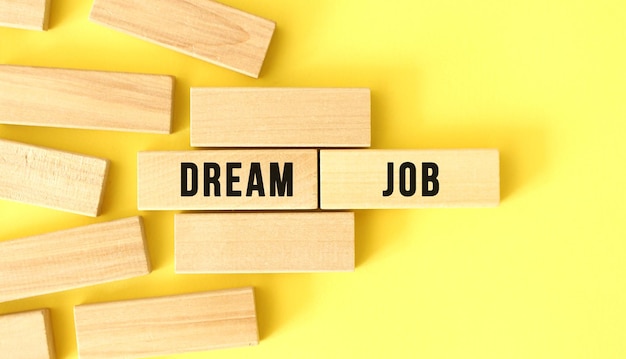 DREAM JOB text written on a wooden blocks on a yellow background