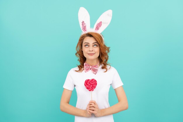 Dreamy easter woman wear bunny ears hold heart lollipop