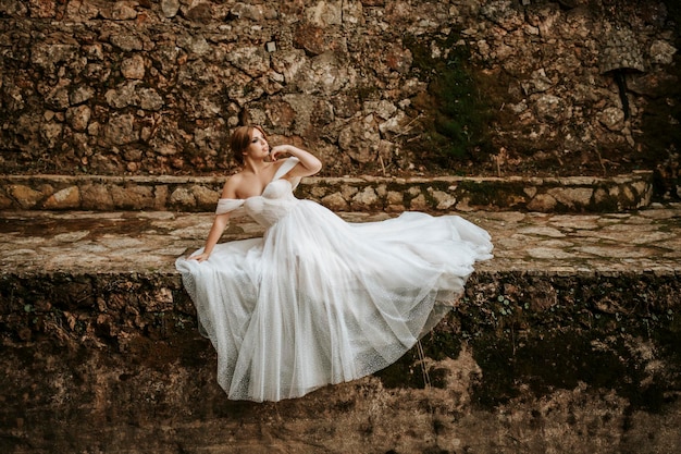 Dreamy portraits of beautiful bride on stone riverbank