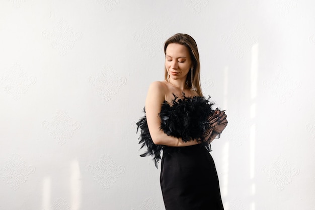 Dreamy woman in corset with feathers with closed eyes