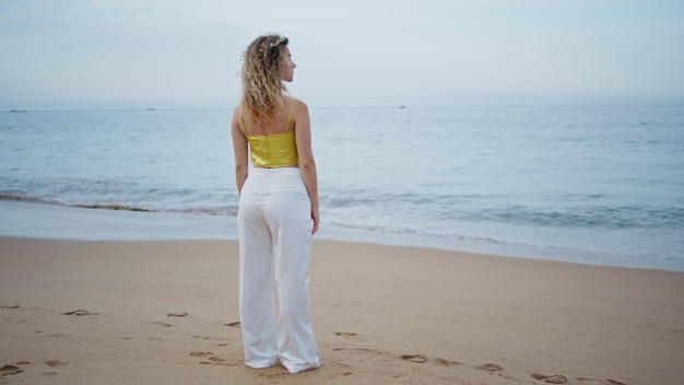 Dreamy woman looking ocean waves summer evening girl contemplating seascape