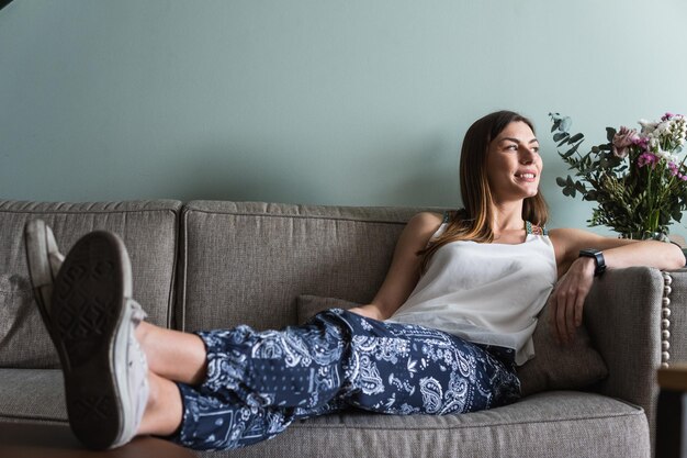 Photo dreamy woman resting on sofa in house