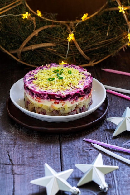 Dressed herring raditional soviet festive salad of herring and vegetables in a new years decoration