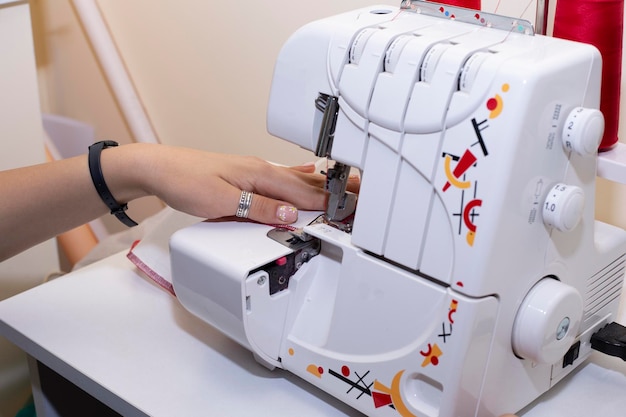 Dressmaker hands sews fabrics on a sewing machine