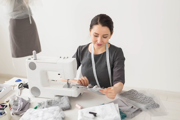 Dressmaker, tailor and creative concept - Portrait of fashion designer with sewing machine over white surface