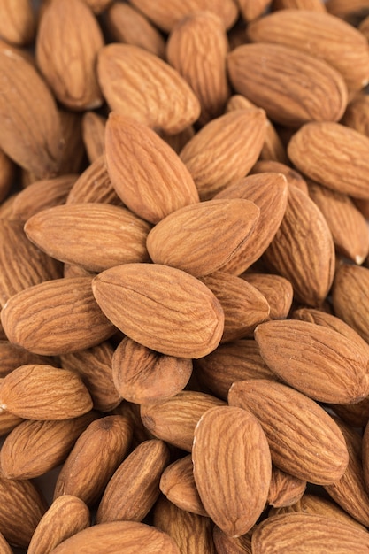 Dried almond seeds in bulk, close-up, top view. Texture. A natural product for the diet. Vertical orientation.