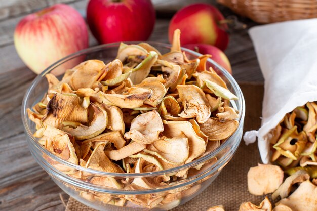 Dried apple slices in a bowl on wooden background. Selective focus.