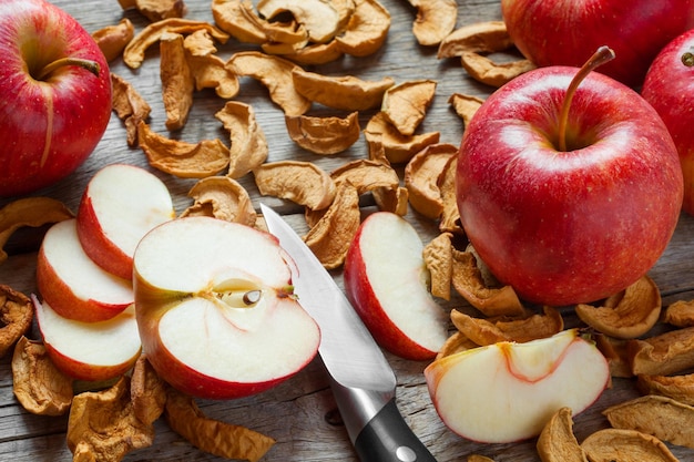 Dried apple slices and red fresh red apple fruit on old wooden kitchen table