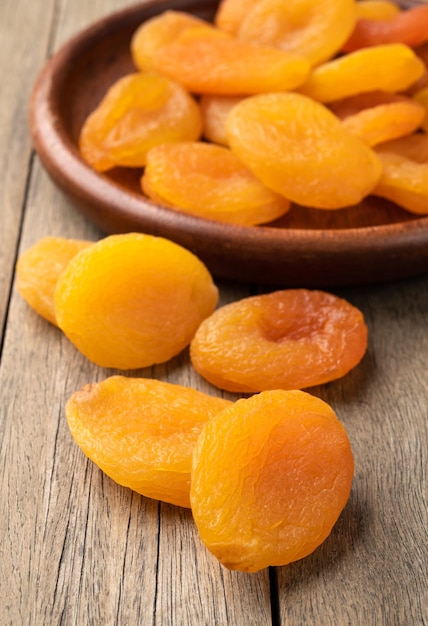 Dried apricots in a plate over wooden table