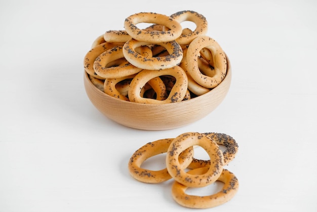 Dried bagels with poppy seeds in a wooden bowl on a white background