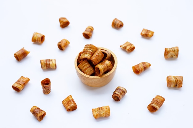 Dried banana rolled chips on white background.